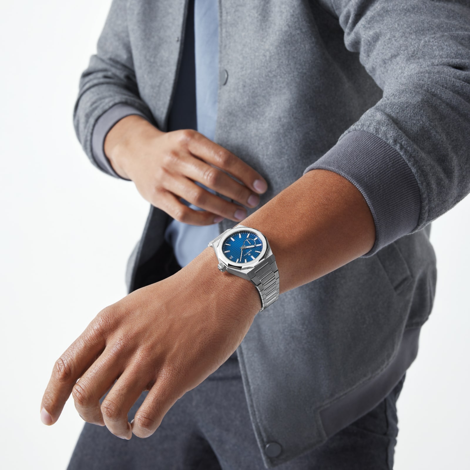 Model wearing a blue Zenith DEFY Skyline with a grey knit top.